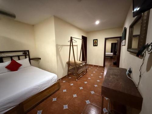 a bedroom with a bed and a tiled floor at Hotel Hacienda Tonalmain, Central Nueva in Guadalajara