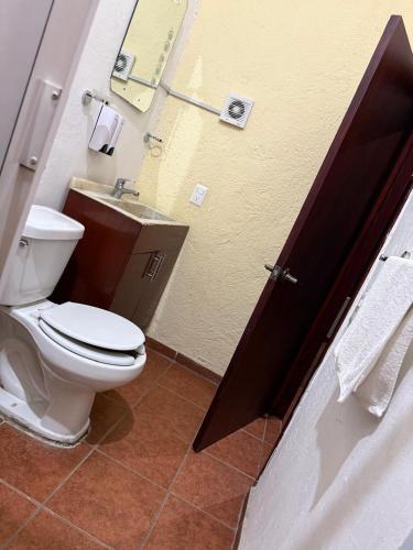 a bathroom with a toilet and a sink at Hotel Hacienda Tonalmain, Central Nueva in Guadalajara