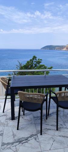 a black table and chairs with a view of the ocean at Two Palms Apartment in Sutomore