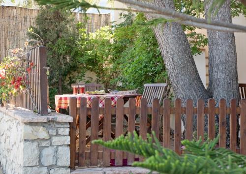a wooden fence with a table and a tree at Filoxenes Katoikies in Dhiakofti