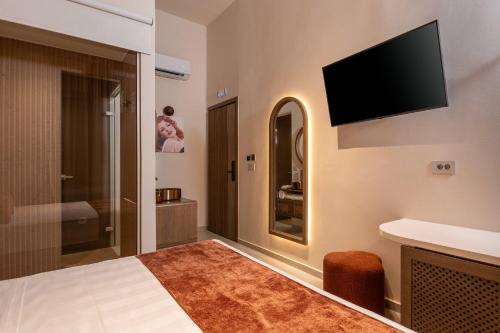 a hotel room with a bed and a television on the wall at Madonna del Mare City in Chania Town