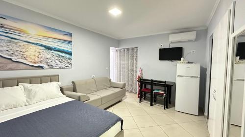 a bedroom with a bed and a couch and a desk at Bebi Guest House in Sarandë