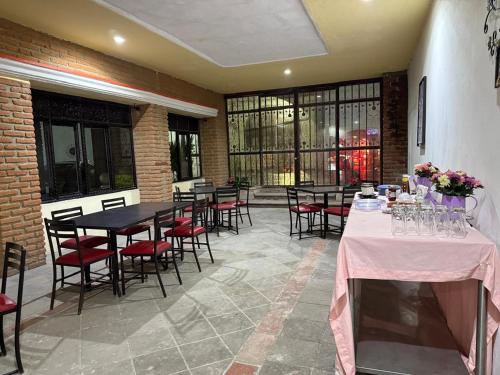a dining room with tables and chairs and windows at Hotel Hacienda Tonalmain, Central Nueva in Guadalajara