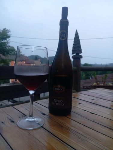 a bottle of wine and a glass on a table at Casa Umberna in Asiago
