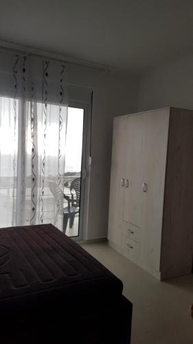 a bedroom with a bed and a dresser and a window at Apartment 7 in Bar, Susanj