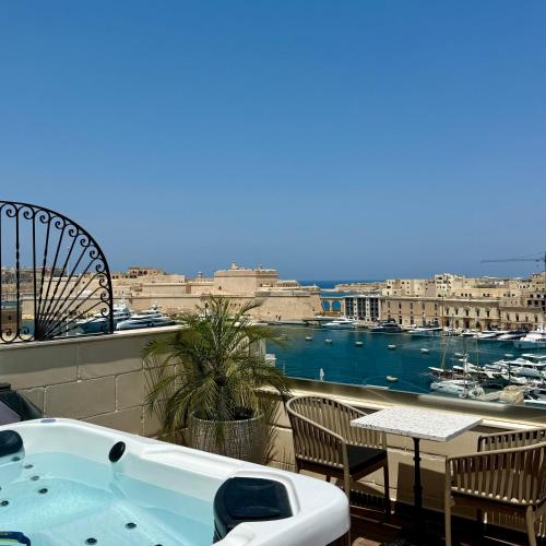 a bath tub on a balcony with a view of a harbor at Palazzo De La Sengle Boutique Hotel in Senglea