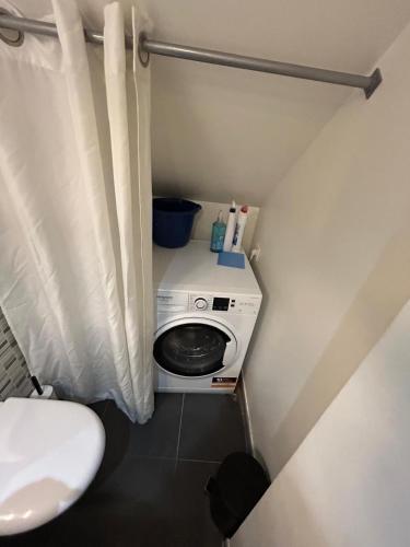 une petite salle de bains avec un lave-linge et des toilettes. dans l'établissement AS app, à Reims