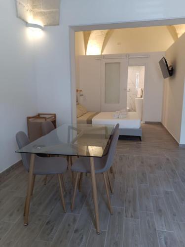 a table and chairs in a room with a bed at VENTINOVE Apartments in Otranto