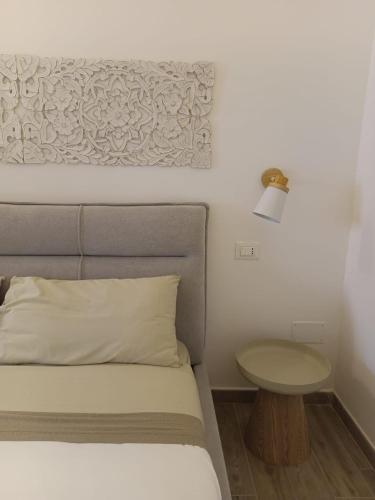 a bedroom with a bed with a table next to it at VENTINOVE Apartments in Otranto