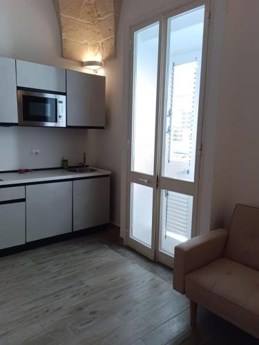 a kitchen with a couch and a microwave and a window at VENTINOVE Apartments in Otranto
