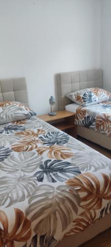 two beds sitting next to each other in a room at Apartman Car in Vir