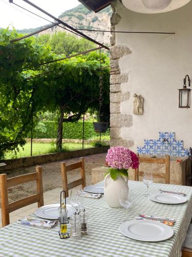 une table avec des assiettes et un vase de fleurs dans l'établissement leGuilherand, à Guilherand