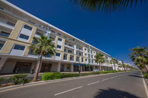 アガディールにあるSea Side Mountain View Apartmentのヤシの木が茂る建物前の空き道
