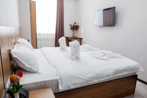 a white bed with towels on top of it at Centrum Hotel Tashkent in Tashkent