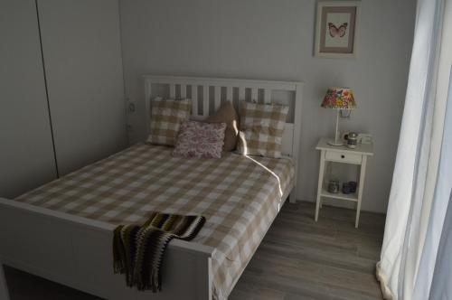 Dormitorio pequeño con cama con manta a cuadros en Apartment Vela, en Neum