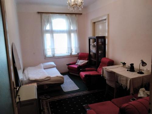 una sala de estar con un sofá, una mesa y sillas en Terazije Beograd, en Belgrado