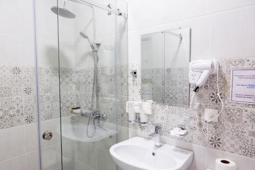 a bathroom with a shower and a sink at Centrum Hotel Tashkent in Tashkent