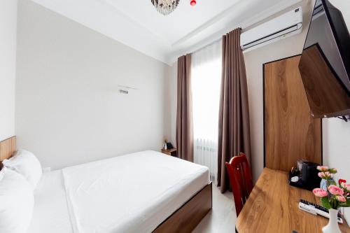 a hotel room with a bed and a wooden table at Centrum Hotel Tashkent in Tashkent