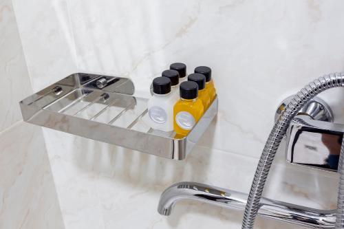 a bathroom sink with a soap dispenser on a counter at Centrum Hotel Tashkent in Tashkent