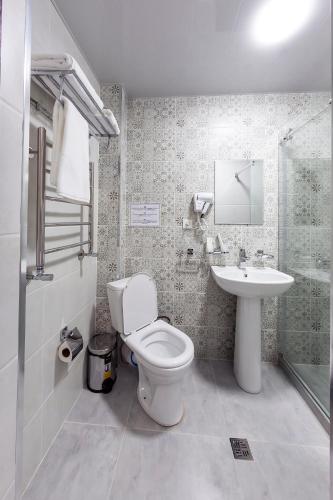 a bathroom with a toilet and a sink at Centrum Hotel Tashkent in Tashkent