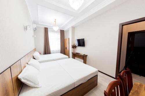 a hotel room with a bed and a television at Centrum Hotel Tashkent in Tashkent