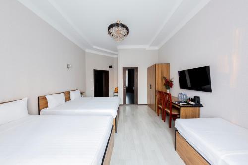 a hotel room with two beds and a tv at Centrum Hotel Tashkent in Tashkent