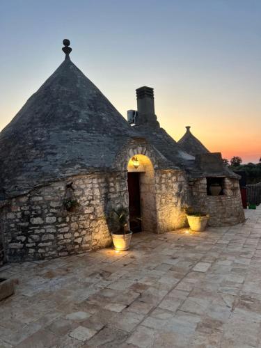 an old stone building with a sunset in the background at Bed & breakfast vecchia vallata in Gioia del Colle