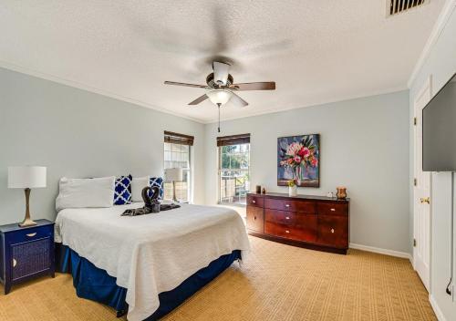 Un dormitorio con una cama y un ventilador de techo. en Cozy Bungalow Steps from Downtown Mount Dora, en Mount Dora