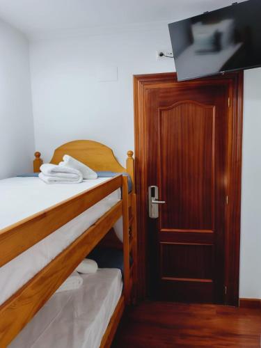 a room with two bunk beds and a flat screen tv at Casa MARIO y MARIOLA in El Dueso