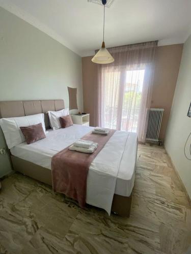 Un dormitorio con una cama grande con una ventana grande. en Jenny's House Nafplio, en Nauplia