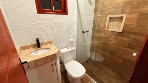a bathroom with a toilet and a sink and a shower at Chalés Raios de Sol in Monte Verde
