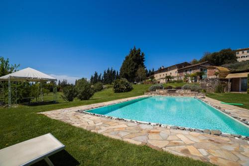 a swimming pool in a yard with a stone walkway at Relais Del Lago in Capannori