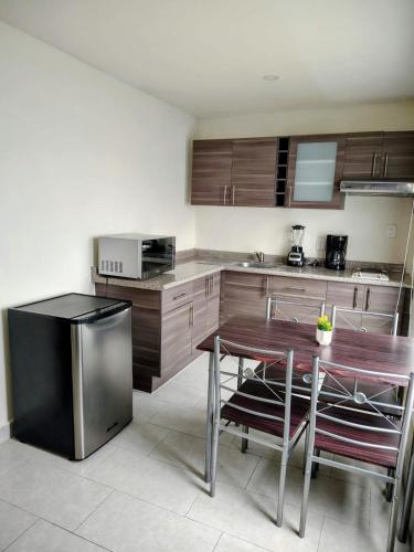 a kitchen with wooden cabinets and a wooden table and chairs at Hotel Casa 20 in León