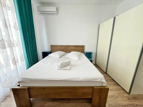 a bed with white sheets and pillows in a bedroom at AVIATORII Modern Escape Apartment in Constanţa