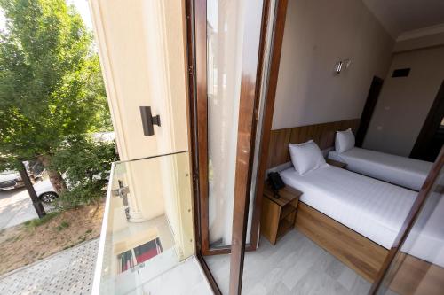a small room with a bed and a window at Centrum Hotel Tashkent in Tashkent
