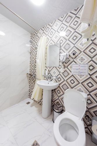 a bathroom with a toilet and a sink at Centrum Hotel Tashkent in Tashkent