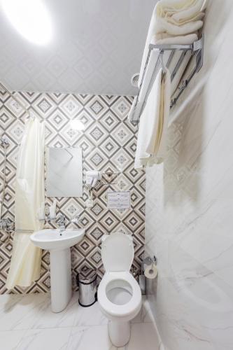 a bathroom with a toilet and a sink at Centrum Hotel Tashkent in Tashkent