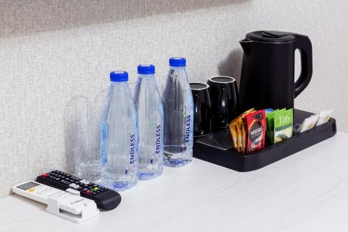a group of bottles and a remote control on a shelf at Centrum Hotel Tashkent in Tashkent