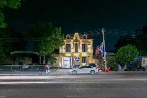 a white car parked in front of a building at night at Centrum Hotel Tashkent in Tashkent
