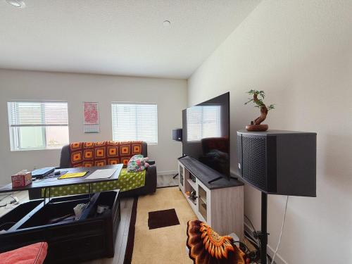 Una sala de estar con un sofá y un televisor. en ALTA Elk Grove Stylish Retreat, en Elk Grove