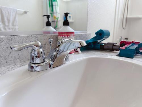 un lavabo con un grifo de plata. en ALTA Elk Grove Stylish Retreat, en Elk Grove