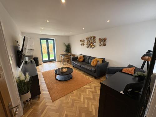 a living room with a couch and a table at 1 The orchard - Beautiful Ground floor garden flat in Frampton Cotterell
