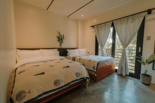 Postel nebo postele na pokoji v ubytování UNLTD Siargao Hotel