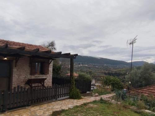 a house with a fence and a view of a city at Μικρό σαλέ. in Pournára