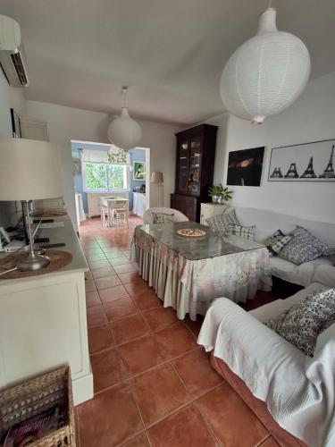 ein Wohnzimmer mit Tisch und Couch in der Unterkunft Casa en Loma Sancti Petri a 900 m de la playa de La Barrosa in Chiclana de la Frontera