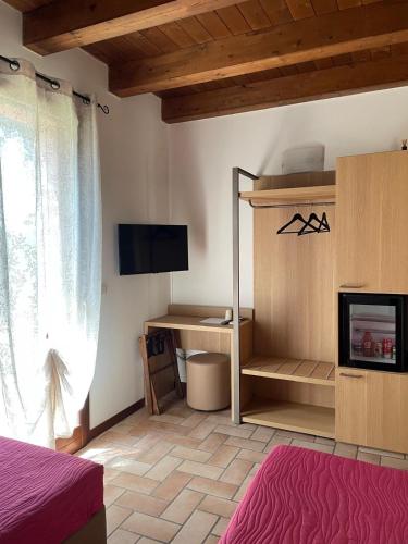 a bedroom with a bed and a desk and a tv at Agriturismo La Rondinella in Dozza