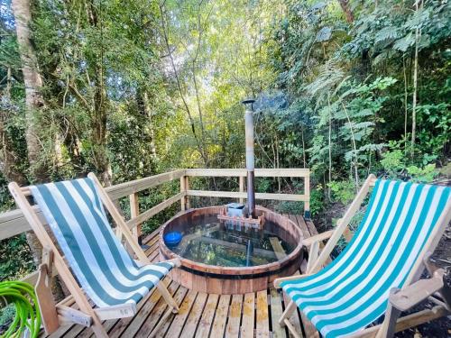 two chairs on a wooden deck with a fire pit at Chalet con Tinaja LicanRay in Challupen