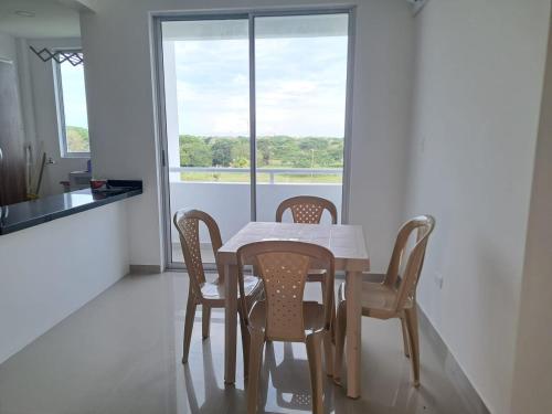 a dining room with a table and chairs and a window at Vacaciones Inolvidables in Coveñas