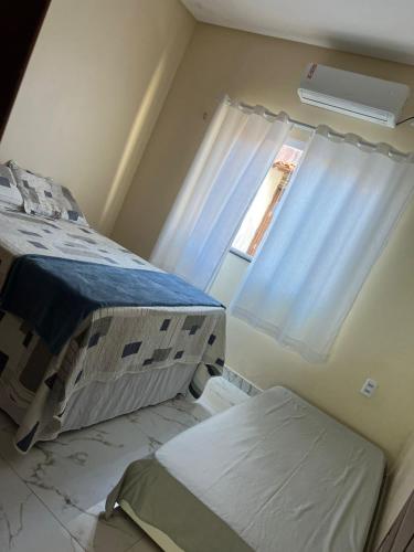 a hospital room with two beds and a window at Resindência Castros in Barreirinhas