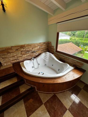 a bath tub in a room with a large window at Hosteria,restaurante,cafeteria Los Abetos in Villanueva de la Peña